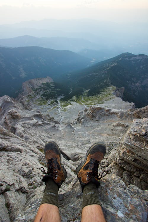 Person in Hiking Boots Sitting on a Rock Edge