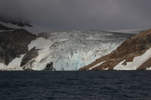 Snow Covered Mountain Near Body of Water