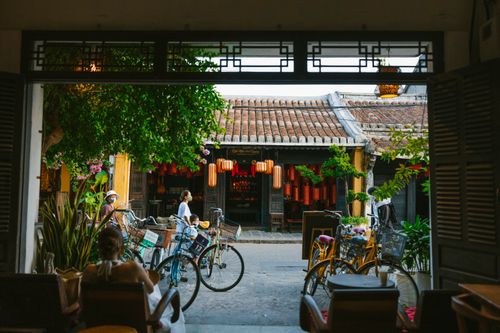 Free Explore a quaint Asian street scene featuring bicycles parked outside a traditional café. Stock Photo