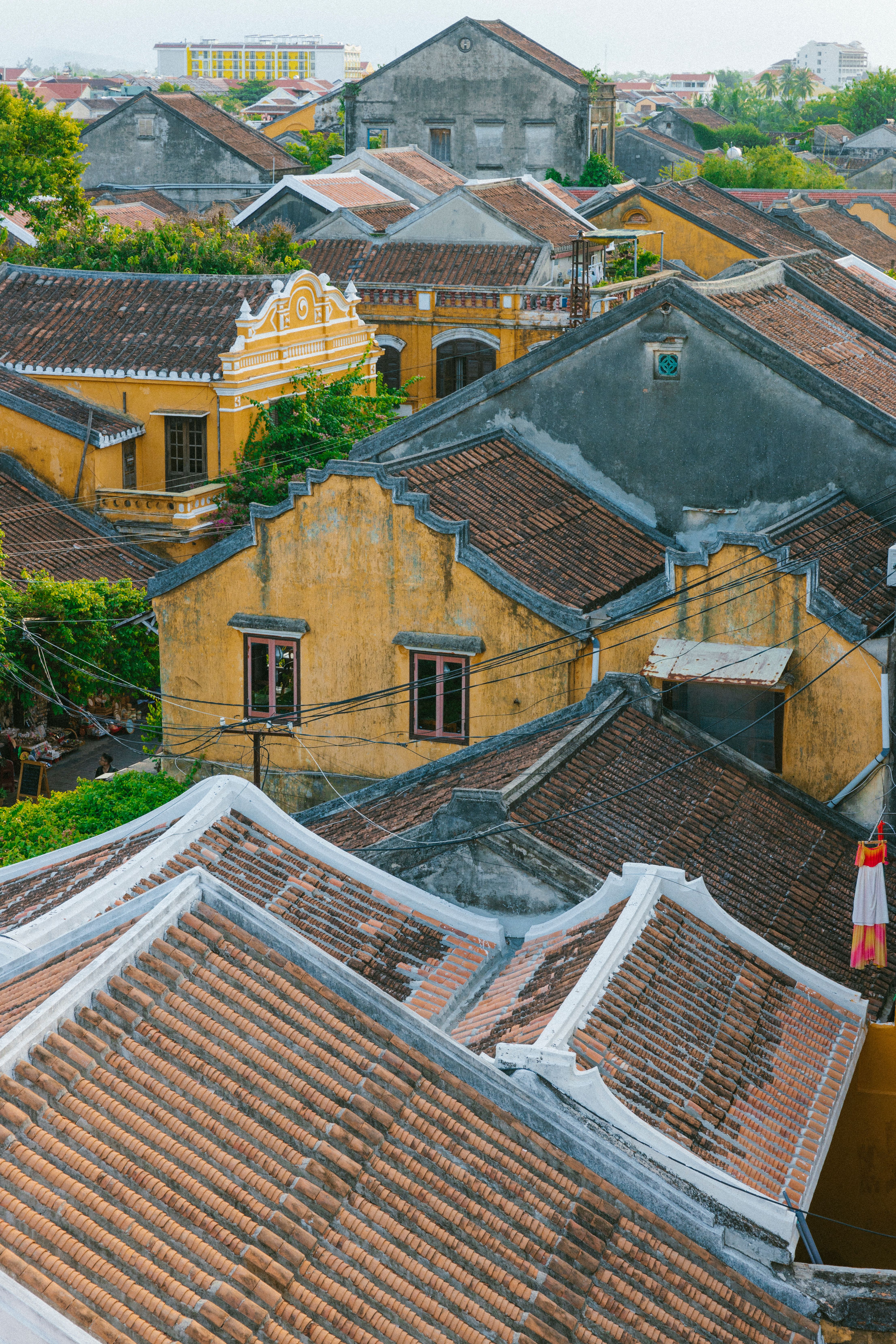 Overhead view of traditional rooftops and yellow facades in Hoi An's historic quarter