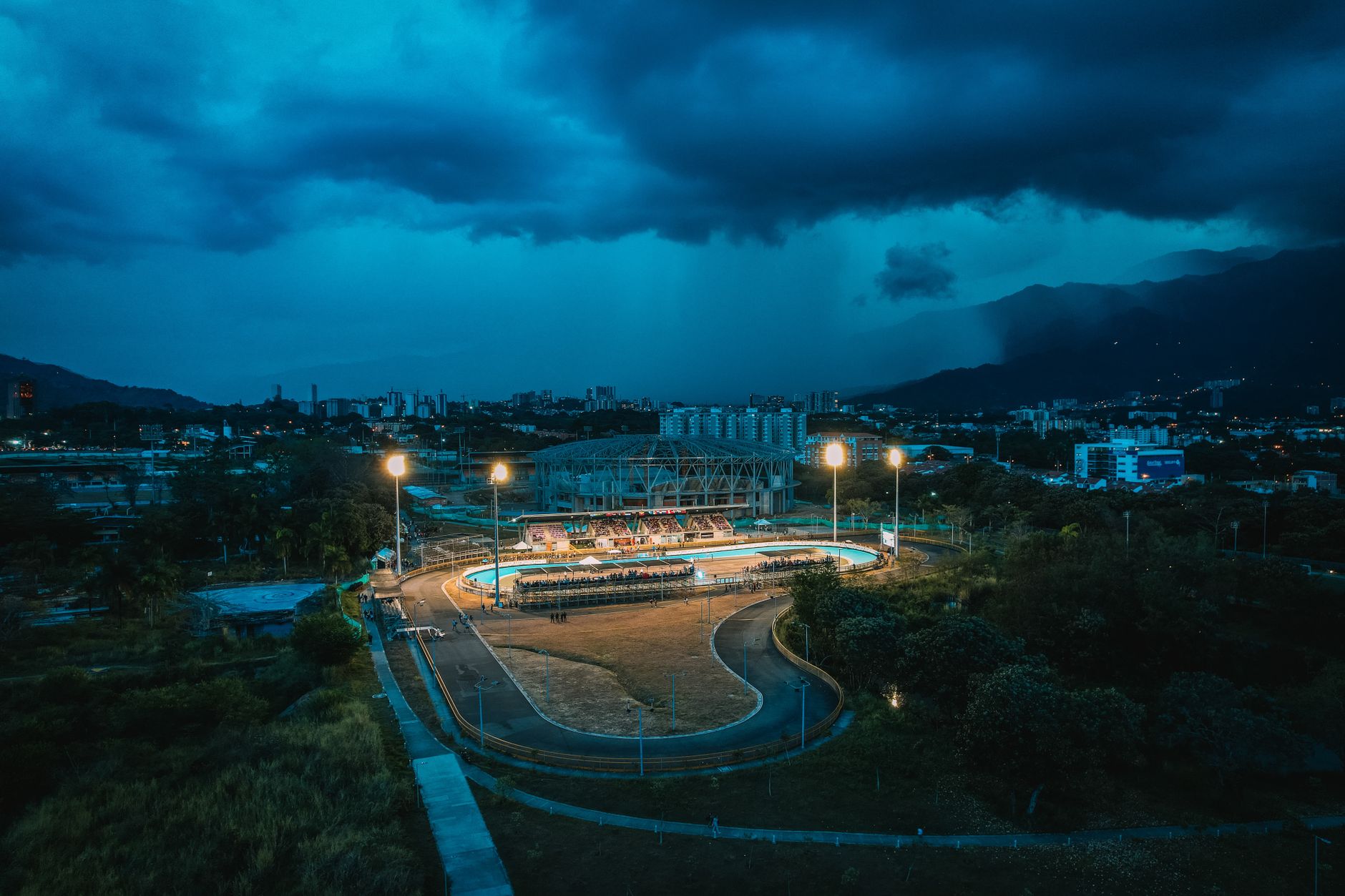 夜間賽馬場燈光照亮跑道,觀眾專注觀看競速賽事