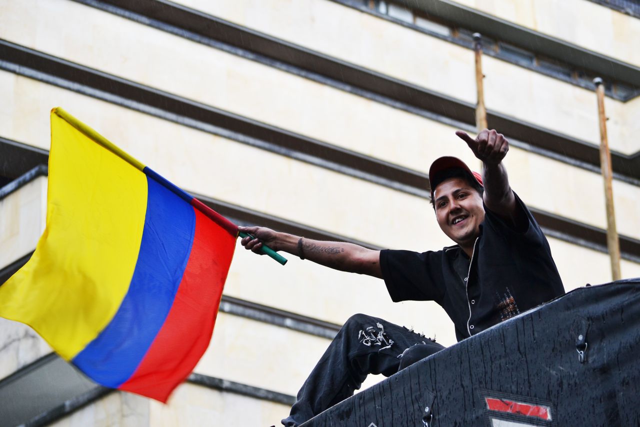 a man joyfully waves the colombian flag in bogot showing national prid