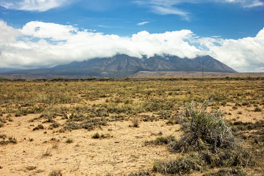 Expansive desert landscape with mountains and a vibrant blue sky creating a serene atmosphere.