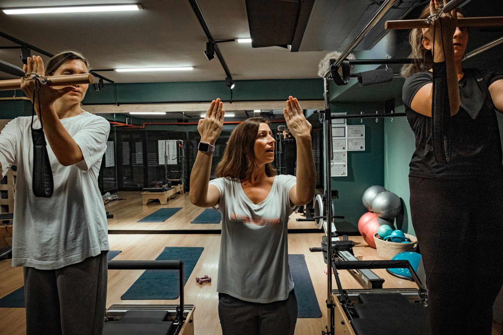 Fitness instructor correcting a student's form during a dance fitness class