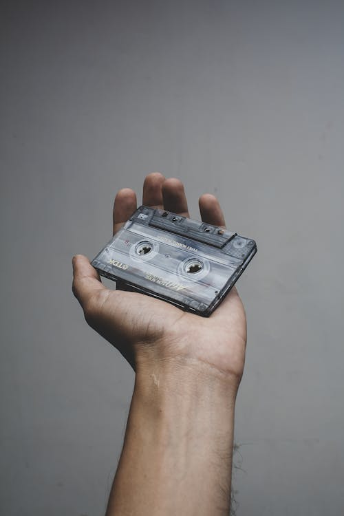 Person Holding a Black Cassette Tape