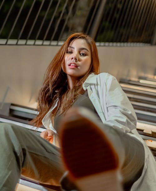 Woman in White Long Sleeve Shirt Sitting on Stairs