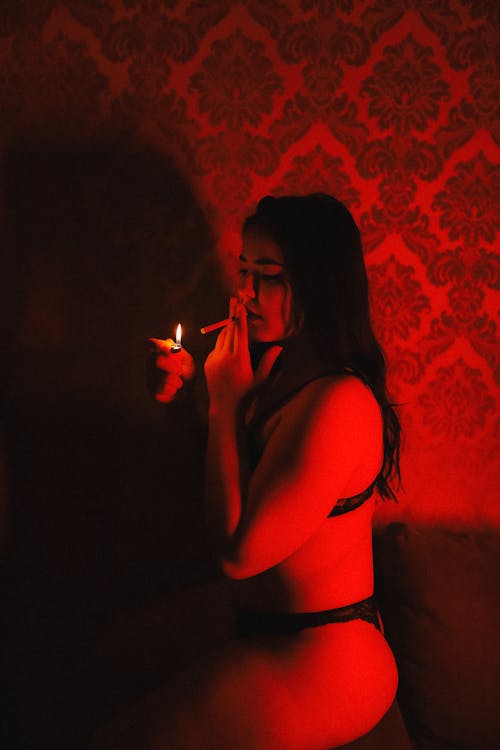 Woman in Lingerie Lighting a Cigarette