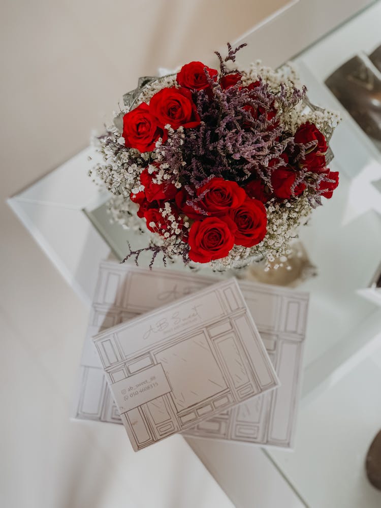 Red Rose Bouquet Beside Invitation Cards