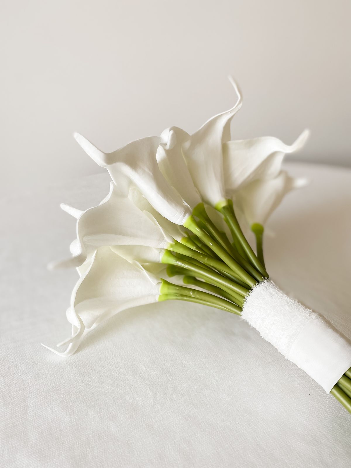 Bouquet of white calla lilies on a white backdrop