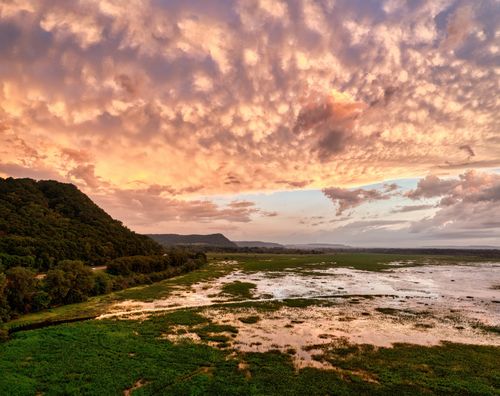 Free Captivating aerial view of Weaver, MN wetlands during a vibrant sunset with dramatic clouds. Stock Photo