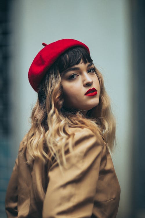 Portrait of Young Beautiful Woman in a Red Beret and a Trench Coat 