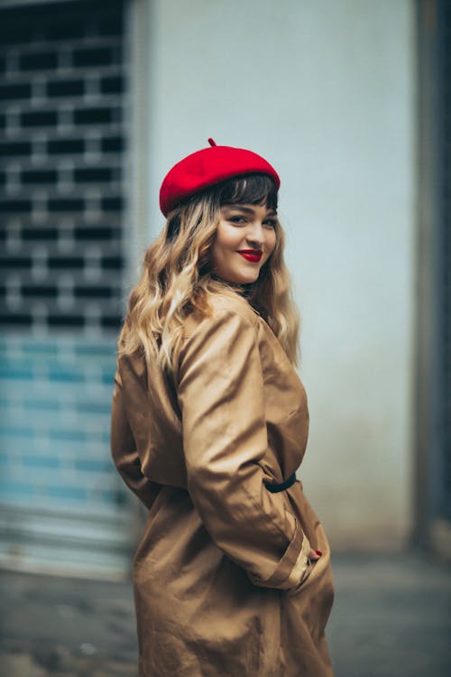 Woman in Red Beret Standing with her Hands in the Pockets of her Trench Coat 