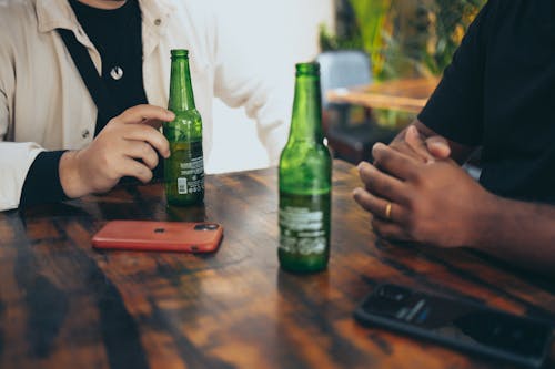 People Dinking Beer in Green Glass Bottle