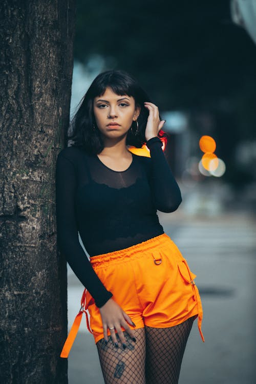 Woman in Orange Shorts on City Street