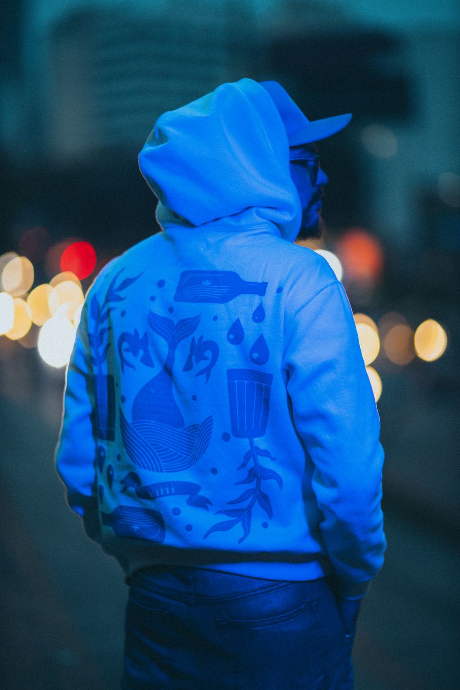Hombre con hoodie y luces nocturnas