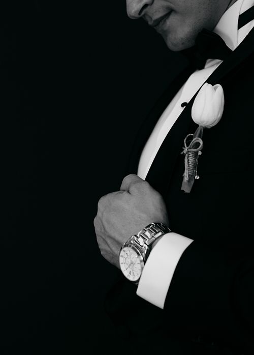 Free Close-up of a man in formal attire wearing a tulip boutonniere and watch. Stock Photo
