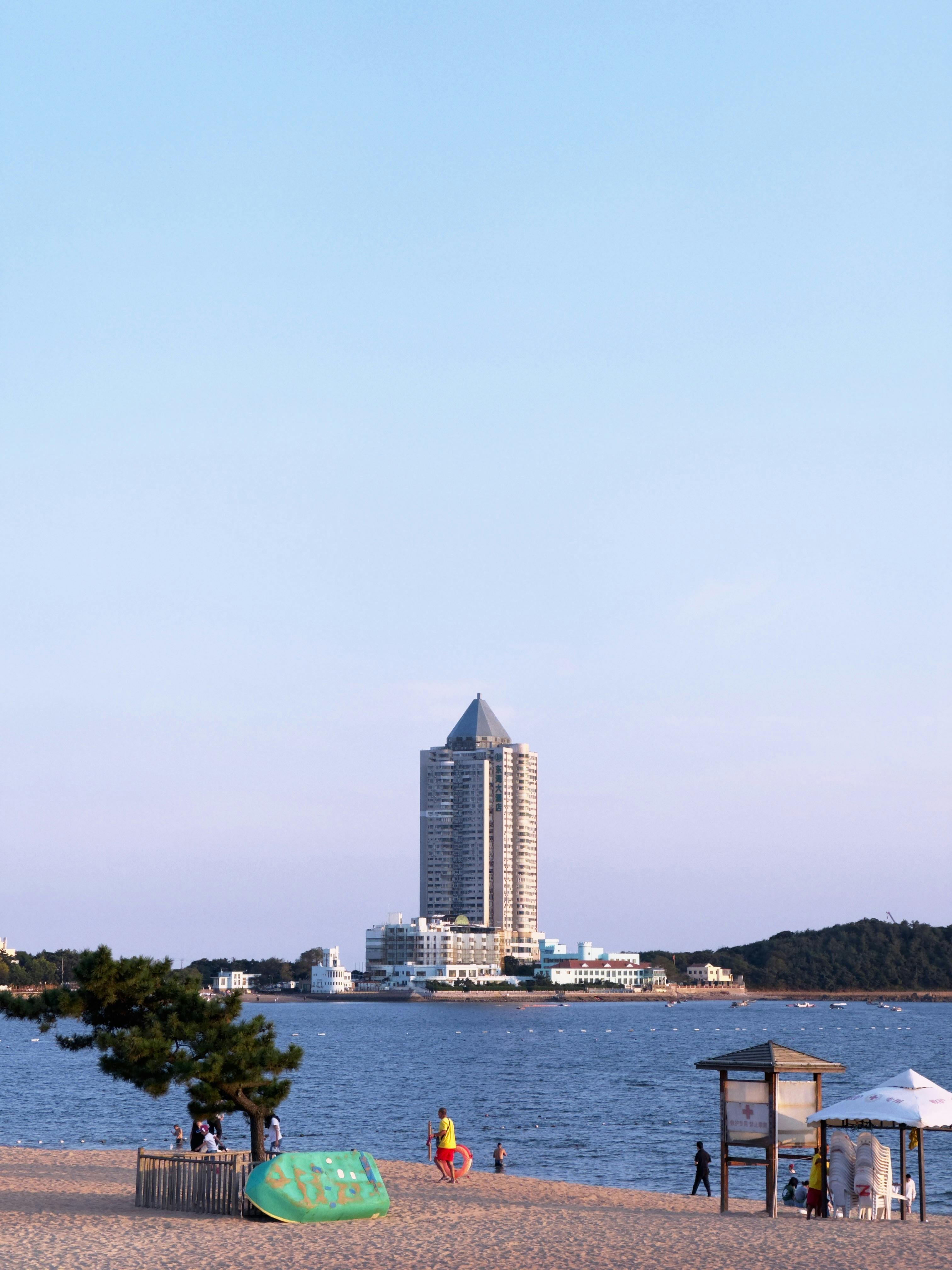 A luxurious beachfront hotel beside the blue sea in a picturesque summer setting.