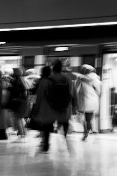 Motion blur of commuters walking at İstanbul train station in black and white.