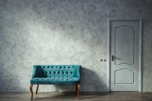 Blue Sofa Near Gray Wooden Door