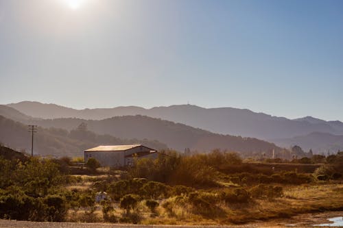 Free Landscape with Hills in Mist and Morning Sun Reflecting in a Cabin Roof Stock Photo