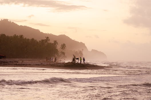 A serene sunset at Palomino Beach in Colombia with people fishing along the shoreline.