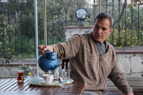 Man Preparing Tea on a Terrace 