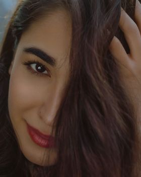 Intimate portrait of a woman with dark brown hair and red lipstick, exuding elegance.