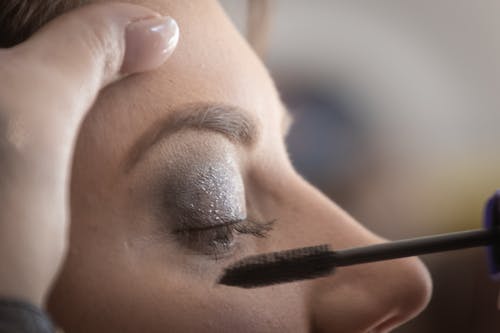 Persona Che Mette Mascara Sulla Donna