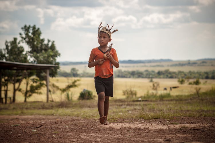 Boy Walking Barefoot On The Ground