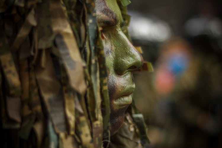 Close Up Photo Of Soldier With Face Paint