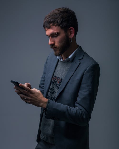 Bearded Man in Blue Suit Jacket Holding a Cellphone