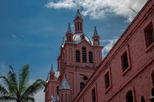 Free Low-angle shot of a brick basilica with towers under a clear blue sky, showcasing architectural beauty. Stock Photo