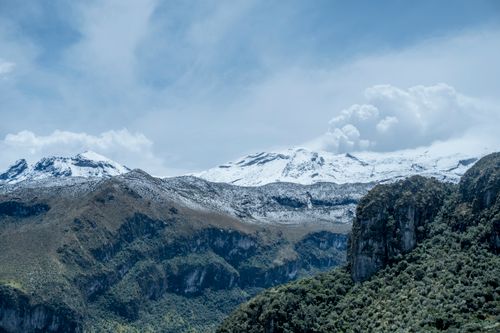 Free Stunning snow-capped mountains with a dramatic cloudy sky, showcasing serene nature. Stock Photo