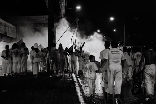 Free A vibrant night parade in Phuket, Thailand capturing a lively crowd and smoke. Stock Photo