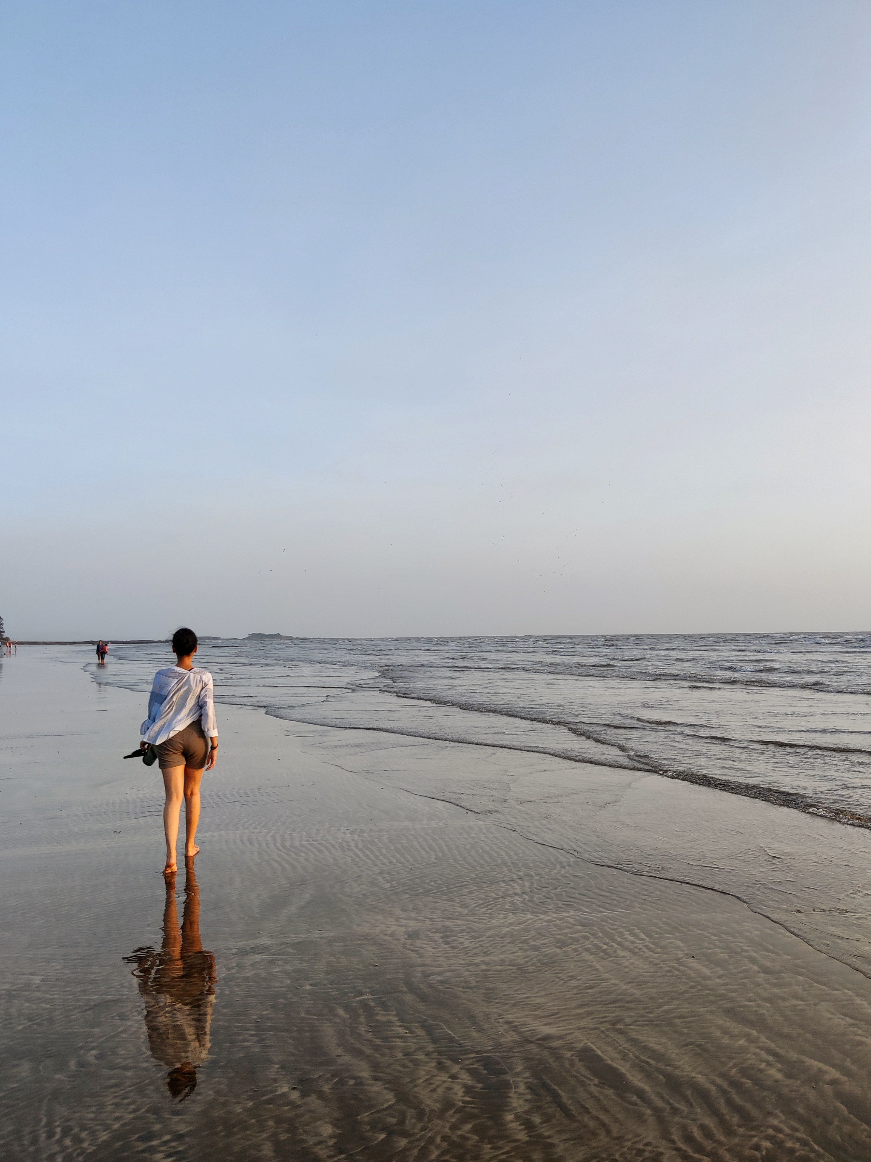 Woman in White Long Sleeve Shirt Walking on Beach · Free Stock Photo
