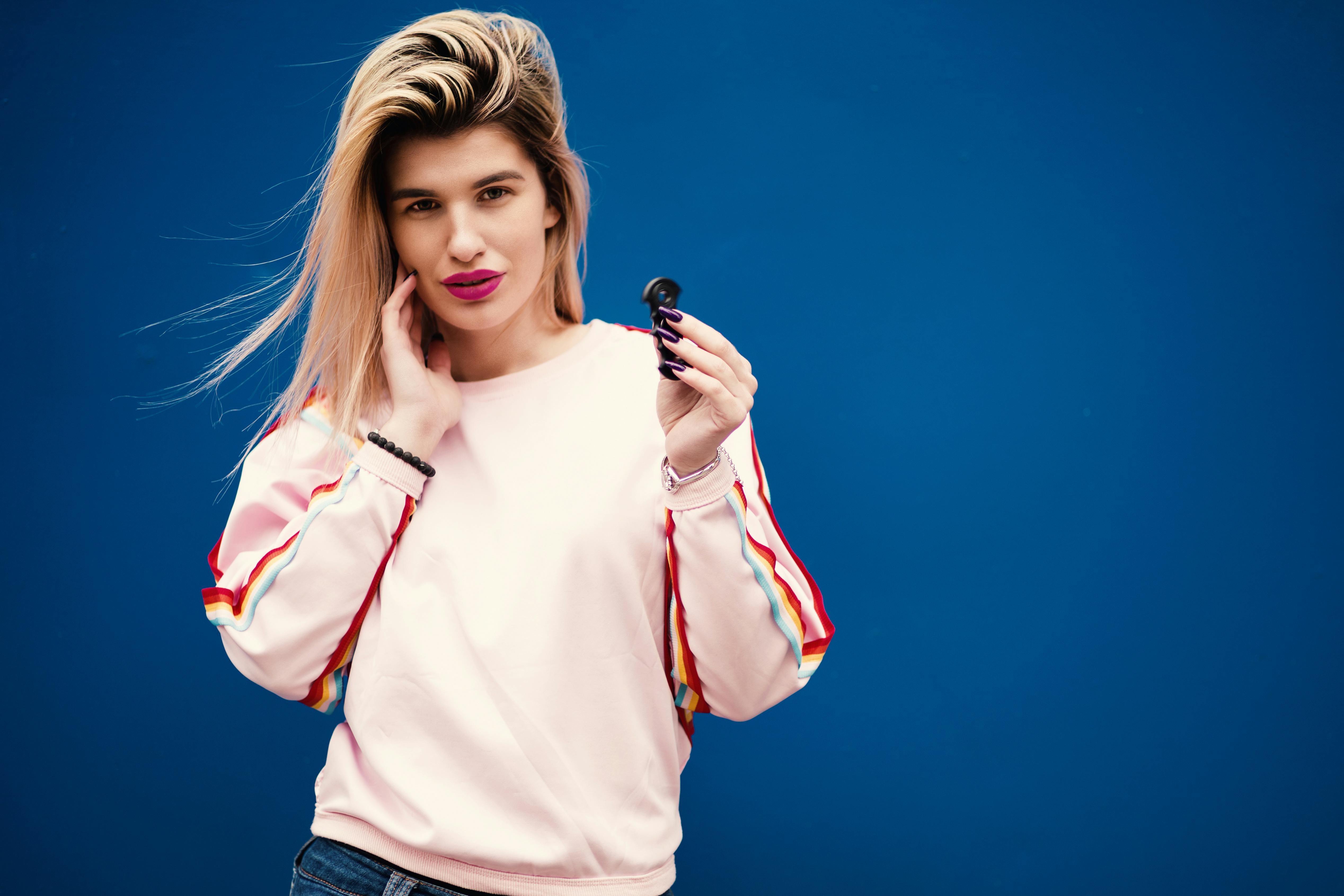 时尚的年轻女子与旋转器构成不安的互动，突显时尚与嬉戏