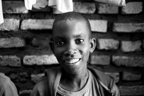 Grayscale Photo of a Boy Smiling 
