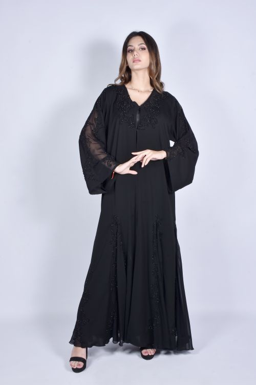 Free Stylish woman wearing a black embellished abaya in a studio setting. Stock Photo