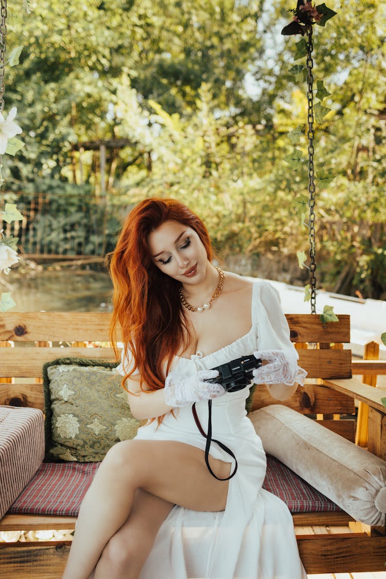 Woman In White Dress Holding A Camera