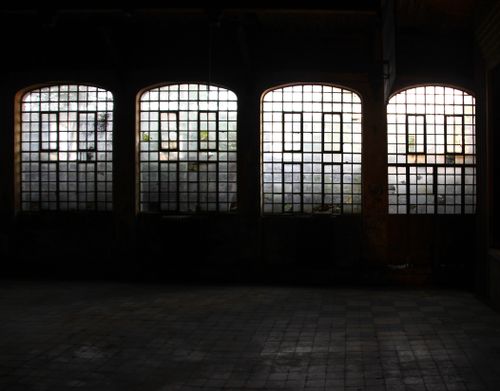 Free A dark, atmospheric interior with grid-patterned windows and pavers. Stock Photo