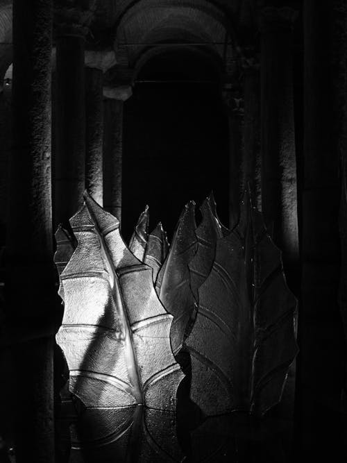 Glass Leaf Sculptures in a Dark Cistern Interior with Columns