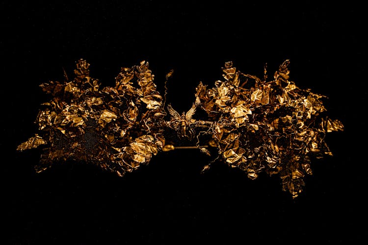 Studio Shoot Of A Golden Brooch Against Black Background