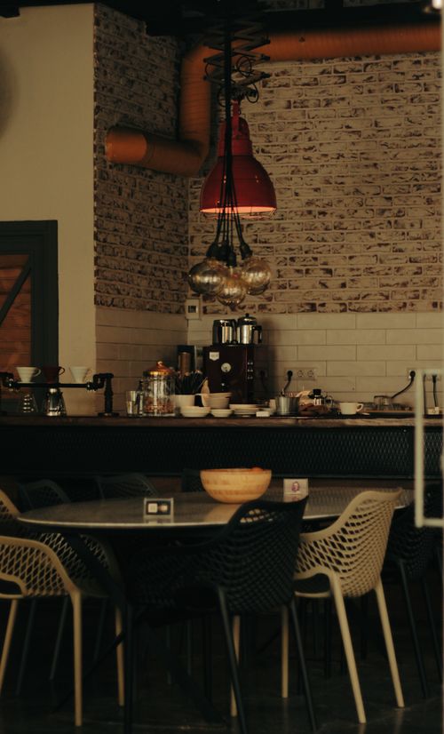 Free Warm, inviting café interior with industrial elements and stylish furniture. Stock Photo
