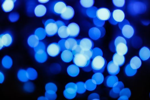 Blurred abstract blue bokeh lights on a dark background, creating a dreamy atmosphere.