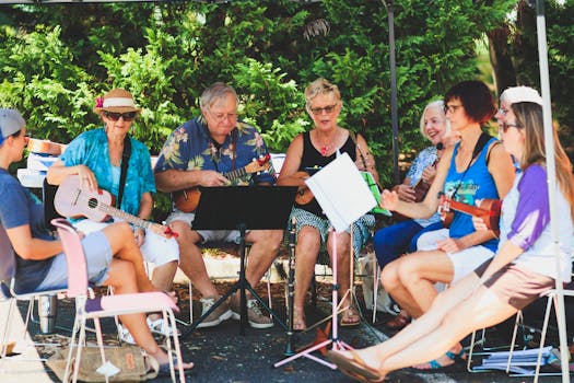 一群快乐的成年人在户外树冠下弹奏尤克里里