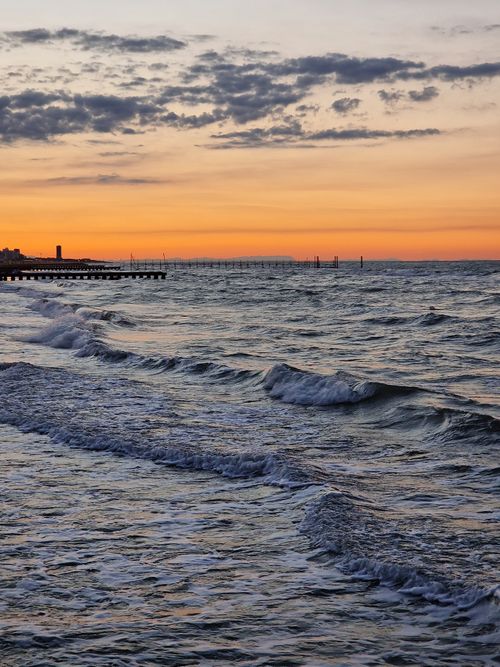 Free Captivating sunset over the waves of Jesolo Beach, Italy, showcasing vibrant skies and tranquil sea. Stock Photo