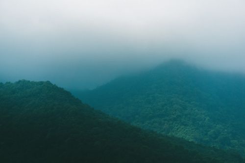 Free Serene misty mountain scene in Butwal, Lumbini Province, showcasing fog rolling over lush forested peaks. Stock Photo