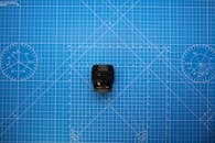 A Black Camera Lens in a Blue Measuring Board