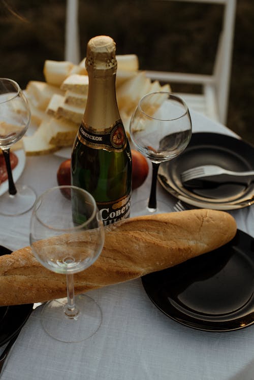 Glasses, Baguette and Champagne Bottle on Table