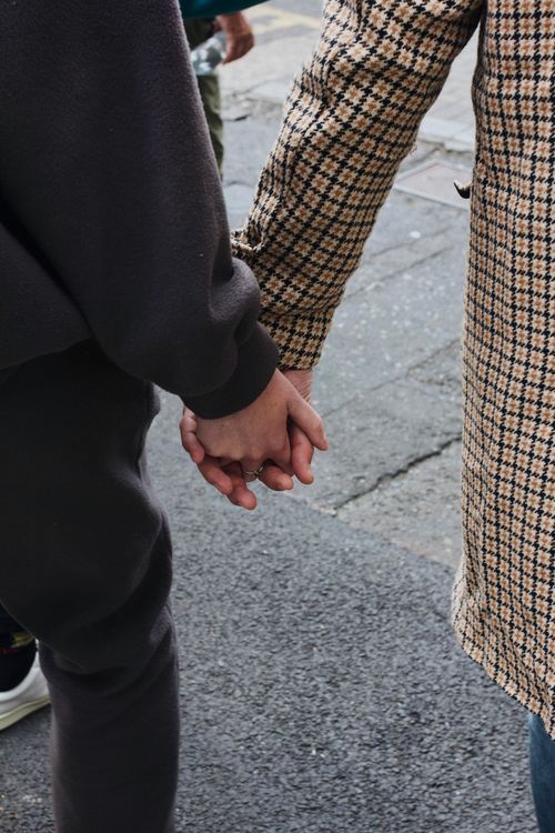 Free Two adults holding hands in Dublin, Ireland. Captures a candid street moment. Stock Photo